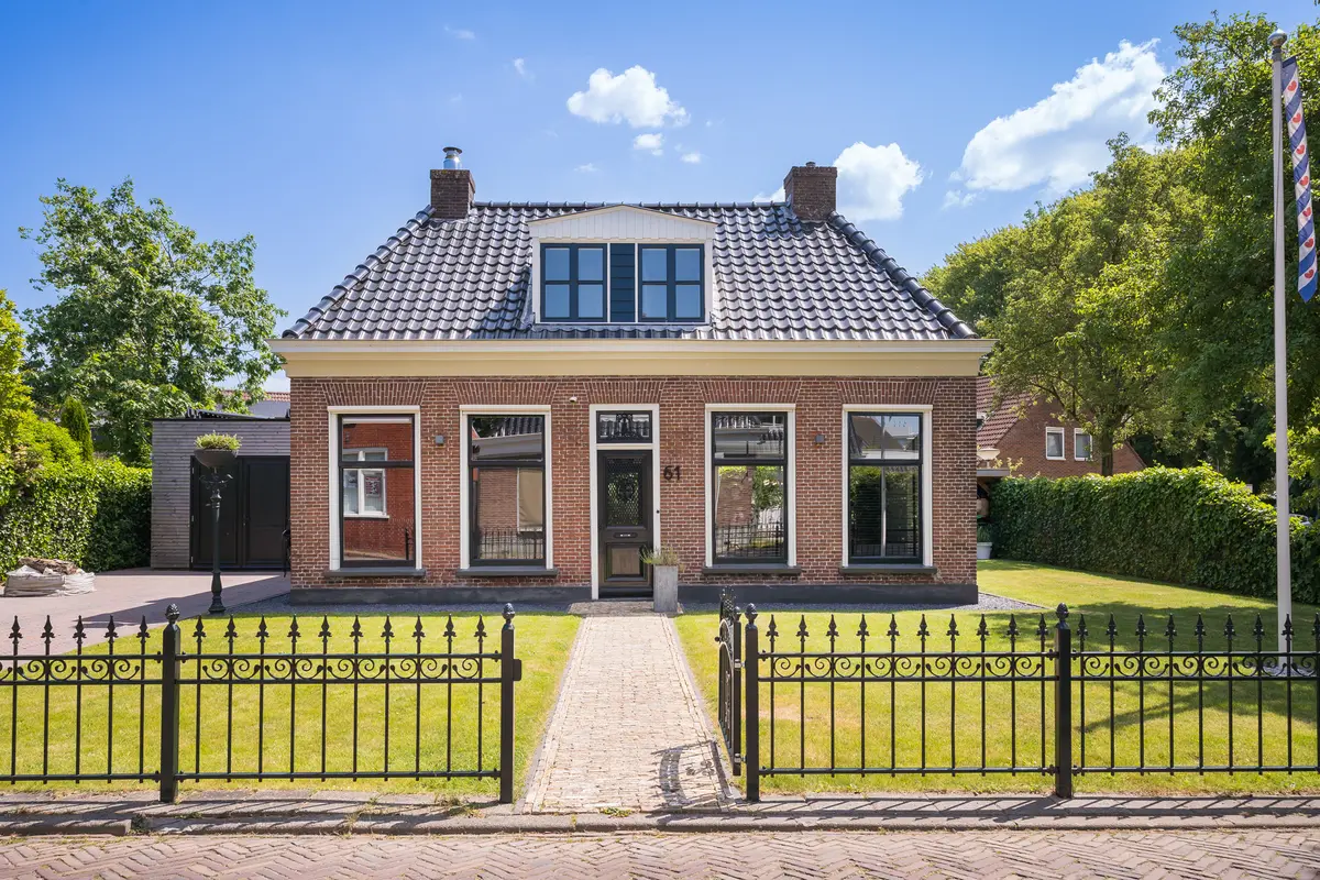 Vrijstaande woning in een groene omgeving en een blauwe lucht.